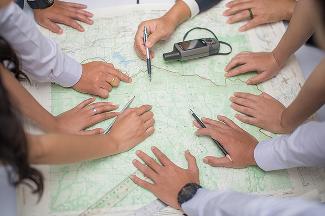 un conjunto de manos de personas analizando un mapa